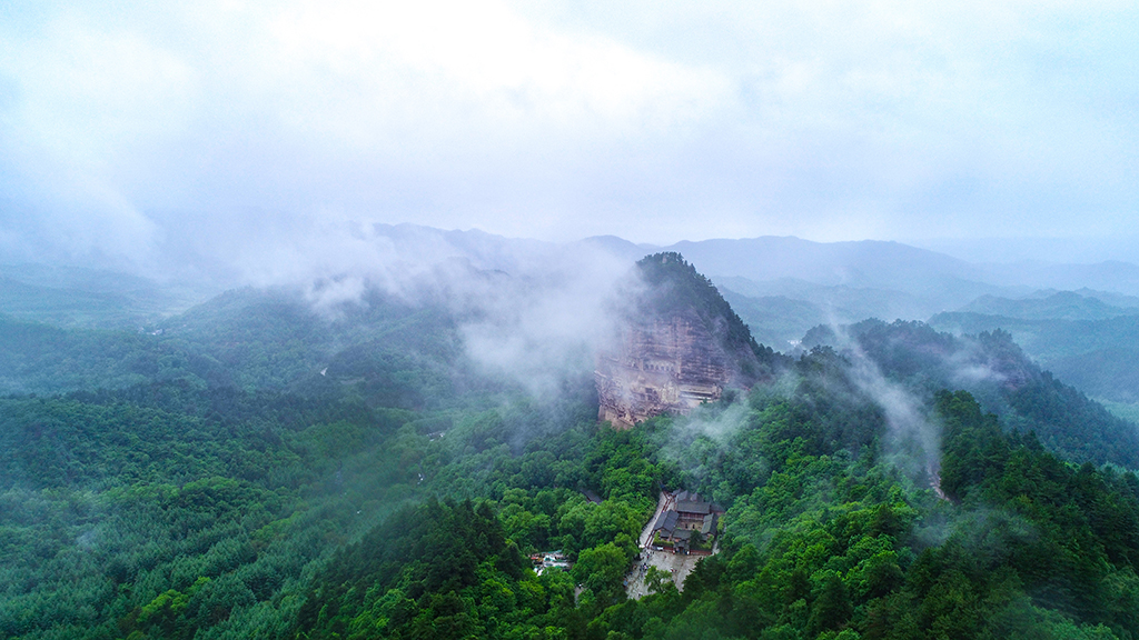 这是5月31日拍摄的烟雨笼罩下的麦积山石窟(无人机照片)。新华社记者 郎兵兵 摄